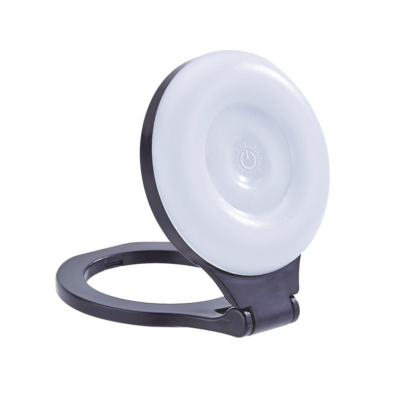 Black ring light with a white circular component on a white background
