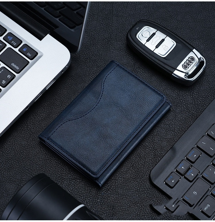 Blue wallet and car key on a desk with a laptop and keyboard in the background