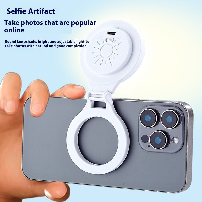 Smartphone with a round lampshade attachment held by a hand on a light blue background