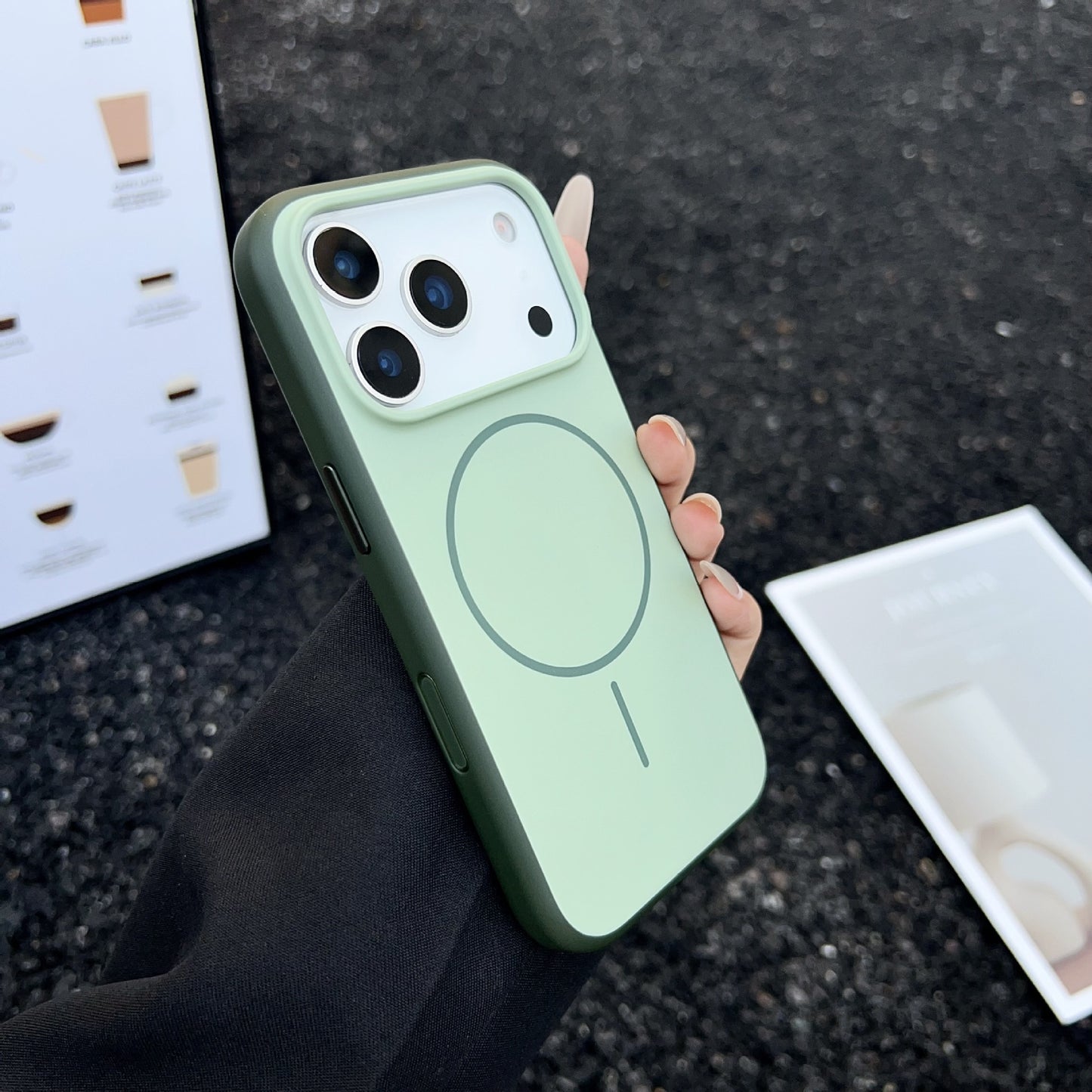 Person holding a green phone case on a dark surface