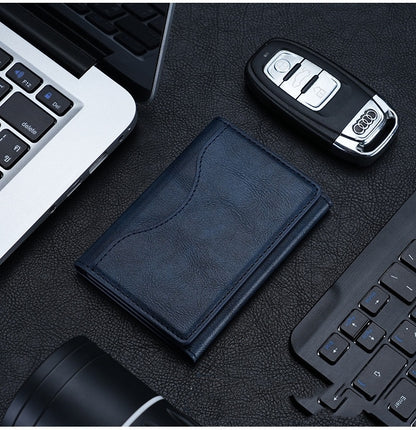 Blue wallet and car key on a desk with a laptop and keyboard in the background