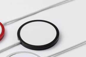 Close-up of a black circular object with red and white elements on a light gray background