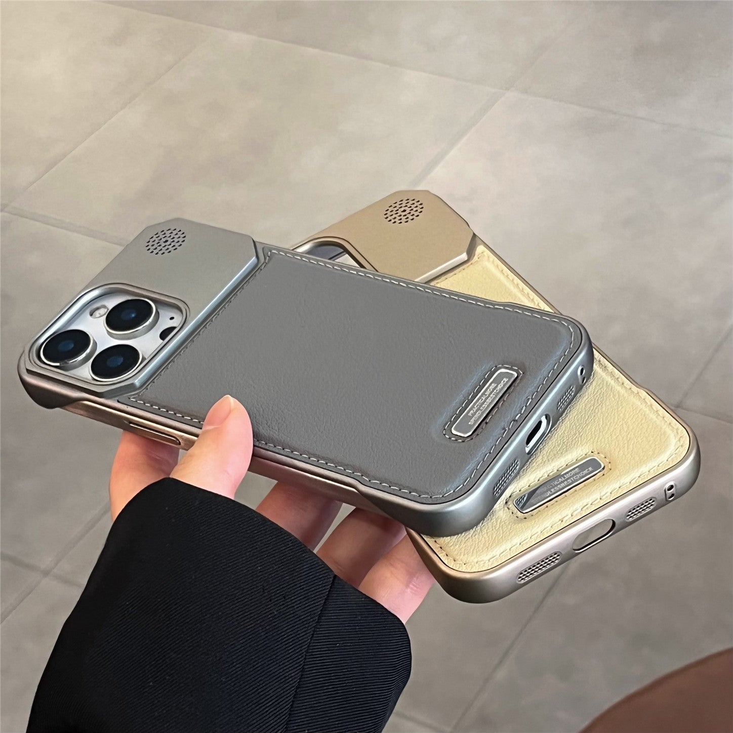 Phone case with multiple colors held by a hand on a tiled floor background