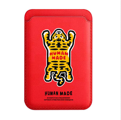 Red phone case with a yellow and black graphic of a bear and 'Human Made' branding on a white background.