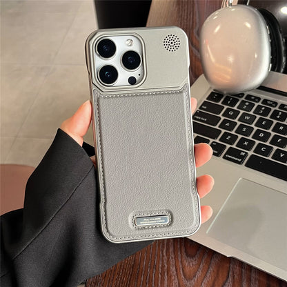 Person holding a gray phone case with a laptop in the background